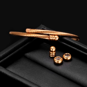 Macro detail of rose gold stainless steel cable bracelet on black leather jewelry box