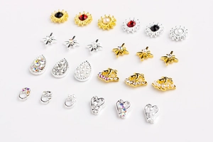 Bijoux à ongles en alliage avec perles et strass sur fond blanc en vue de dessus