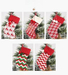 Detail of knitted Christmas stockings with reindeer, tree, and snowflake patterns
