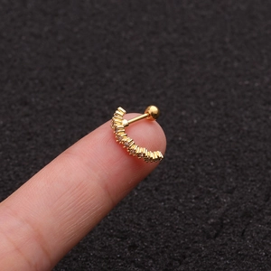 Close-up of golden C-shaped stud earring with clear crystals and screw back on finger