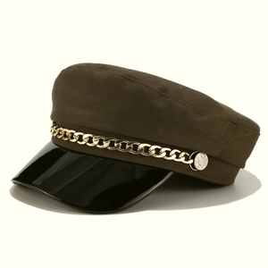 Detail of military cap featuring dark olive canvas, gold chain and black patent leather brim