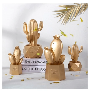 Dettaglio di figurine di cactus oro opaco con basi geometriche e scritte incise