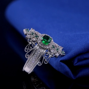 Macro shot of vintage silver copper ring featuring green gemstone and white diamond details