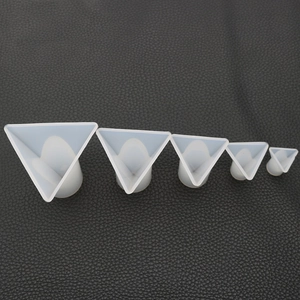 Five assorted sizes of translucent silicone pyramid molds for DIY resin crafts on black leather