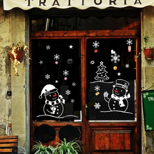 White snowman and snowflake Christmas window stickers on glass storefront doors