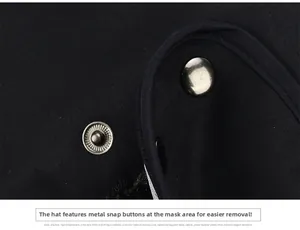 Detail view of the silver metal snap button on a men's black winter trapper hat