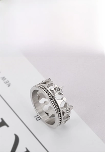 Macro detail of silver crown ring with star patterns and sparkling crystal accents