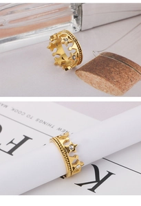 Macro detail of gold crown and star ring with sparkling crystal pave setting