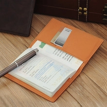 Detail view of orange PU leather travel organizer with pen holder and card slots