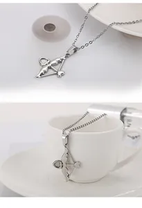 Vue détaillée du collier pendentif cœur et flèche de Cupidon argenté sur une tasse