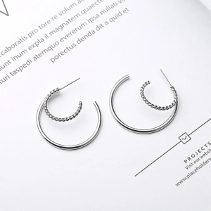 Detail of silver S925 earrings with interlocking smooth and twisted rope rings