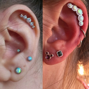 Détail montrant des piercings d'opale et des boucles d'oreilles cartilage ondulées en acier