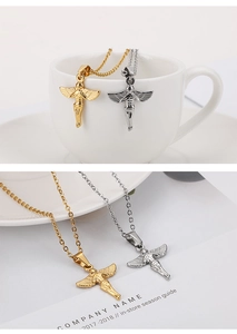 Detailed close-up of gold and silver angel wing pendants hanging on a white ceramic cup