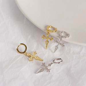 Macro shot of silver and gold cross hoop earrings with sparkling diamond accents