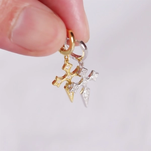 Detail of silver and gold cross hoop earrings with sparkling cubic zirconia stones