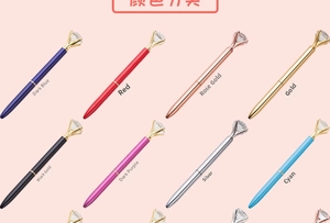 Detailed close-up showing a variety of colorful metal ballpoint pens with large diamond tops