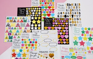 Detail showing assorted gold foil letter stickers and heart shapes for DIY scrapbooking