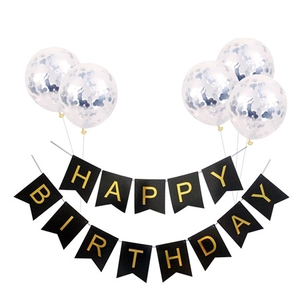 Detail of happy birthday party set with black gold banner and clear sequin balloons