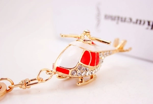 Macro shot of helicopter keychain with red white enamel and sparkling rhinestones