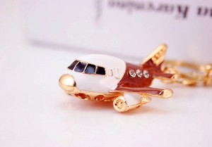 Macro view of gold-plated helicopter keychain with enamel details and sparkling rhinestones