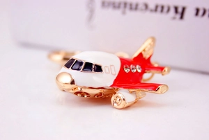 Detailed close-up of a golden A380 airplane keychain with red enamel and rhinestones