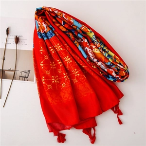 Detail of red ethnic print shawl with fringe tassels and colorful geometric patterns