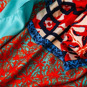 Detailed view of silk scarf with ethnic floral print and baroque geometric border pattern