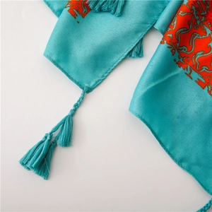 Detail of blue sun-protective shawl featuring ethnic floral patterns and fringe edges