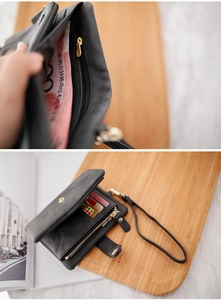 Detail showing the internal zipper pocket and card slots of this black tri-fold wallet