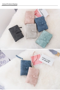 Collection of matte suede trifold wallets in five pastel colors on soft white fur background