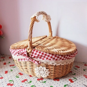 Detail of hand-woven wicker picnic basket with red plaid lining and white lace trim