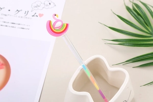 Detail of multi-color ink pen featuring a cute 3D flamingo and rainbow silicone topper