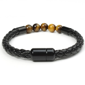 Macro detail of men's black braided leather bracelet featuring tiger eye stones and magnetic clasp
