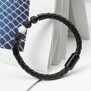 Detail view of men's braided leather bracelet with lava stones and marble beads with magnetic clasp
