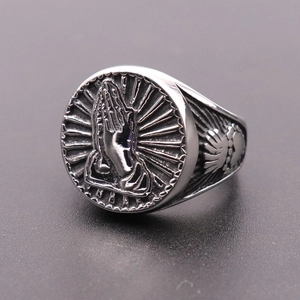 Close-up of vintage silver praying hand relief on a retro style stainless steel ring