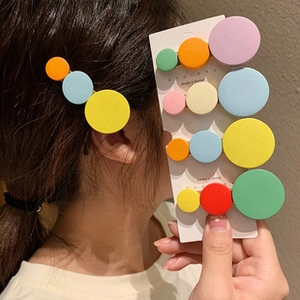 Set of five matte geometric round hair clips in vibrant colors on a display card