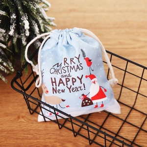 Light blue Christmas gift bag with Santa Claus and elk print in a festive setting