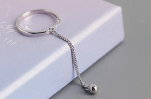 Macro view of S925 sterling silver ring with delicate chain tassel and small bead detail