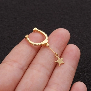 Close-up of a gold star drop ear cuff with micro-paved zircons held between fingers