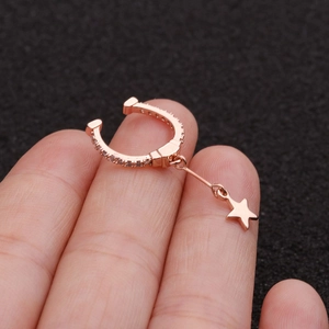 Rose gold star pendant ear cuff with micro-paved zircons shown on finger tip