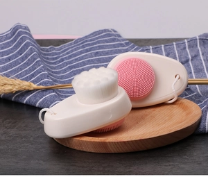 Close-up of dual-sided silicone facial brush with white bristles and pink massage nodes
