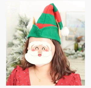 Detail of red and green striped Christmas elf hat with yellow ears and white pompom