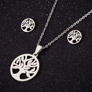 Gros plan sur l'ensemble collier et boucles d'oreilles arbre de vie en acier
