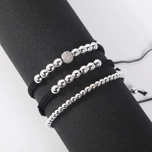 Macro detail of three-piece adjustable braided bracelets with silver beads on a display