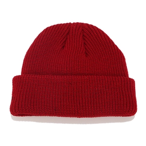 Close-up of deep red ribbed knit beanie showing high-quality woven wool texture