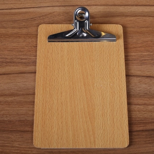 Classic A4 wood clipboard with silver metal clip on a dark textured wooden table surface