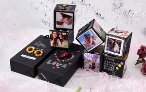 Close-up of DIY exploding gift box with photo cubes, sunflowers and creative decorations