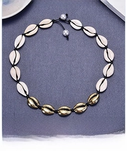 Detail of woven shell necklace with gold alloy accents and pearl pendant decoration