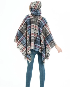 Dettaglio del poncho a quadri con cappuccio, frange e vivace motivo blu e rosso