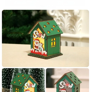 Détail d'une maison de Noël en bois avec lumière LED et motif de neige décoratif
